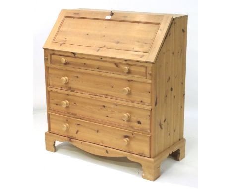 A contemporary pine bureau. The fall opening to reveal a fitted interior, above a frieze drawer and three long drawers, raise