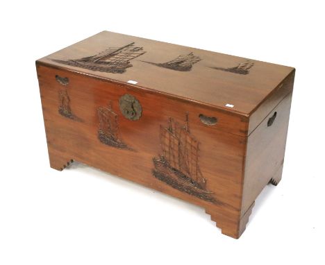 A contemporary camphor wood oriental chest trunk. Carved with Chinese junk boats, raised on bracket supports, L102cm x D50cm 
