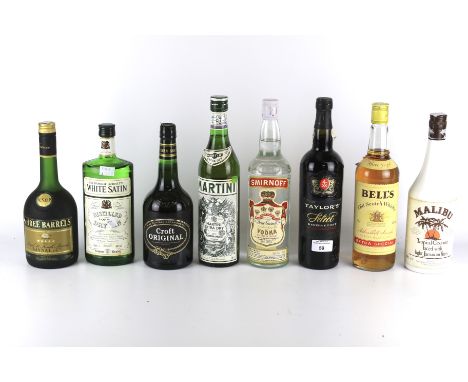 Eight bottles of assorted alcohol. Including Smirnoff vodka, Bell's Old Scotch Whisky, Martin Martini, etc