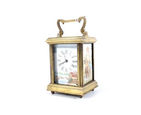 A 20th century small brass carriage clock. The enamel dial with Roman numerals, the ceramic panels on either side decorated w