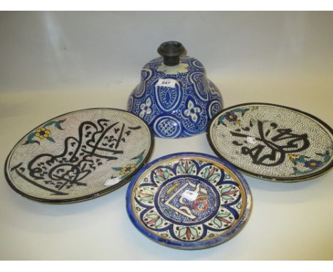 Three North African pottery dishes decorated with Arabic script together with a similar blue and white lid / candlestick base
