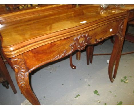 19th Century Continental mahogany serpentine shaped fold-over card table with a figured top, carved frieze and cabriole suppo