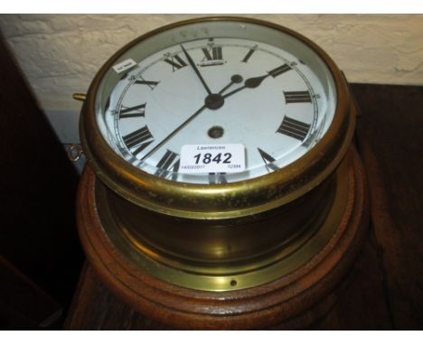 Oak and brass ship's bulk head clock, the enamel dial with Roman numerals and single train key wind movement, 10ins diameter 