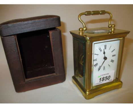 Small brass cased carriage clock with enamel dial, Roman numerals and single train movement with original leather travel case