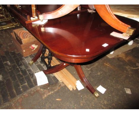 Reproduction mahogany twin pedestal dining table on turned column and tripod bases with single extra leaf