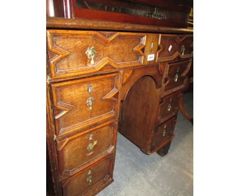 Late 18th / early 19th Century oak kneehole desk with seven geometric moulded drawers and central panelled door raised on lat