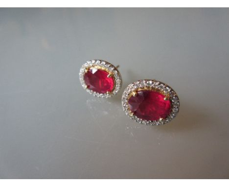 Pair of yellow gold oval treated ruby and diamond cluster ear studs, the rubies approximately 4.5ct total, the diamonds appro