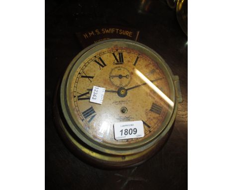 Mid 20th Century ship's gilt brass bulkhead clock by Henry Browne, London, mounted on a wooden plaque inscribed H.M.S. Swifts