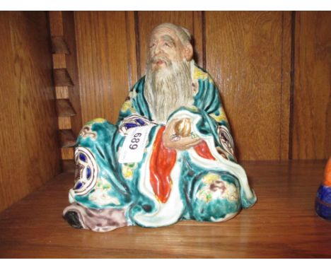 Japanese ceramic figure of a seated immortal having enamel decoration, 6ins high, with impressed seal mark to base, together 