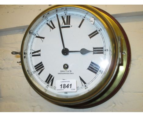 Mahogany and brass ship's bulk head clock, the enamel dial with Roman numerals, signed Smiths, Cricklewood, with a single tra