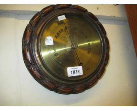 Edwardian circular carved oak aneroid barometer with brass dial inscribed ' The Original Ship's Design, Selfridge, London '