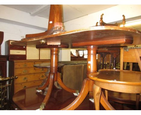 Reproduction yew wood pedestal dining table with a single extra leaf on turned column supports with tripod bases