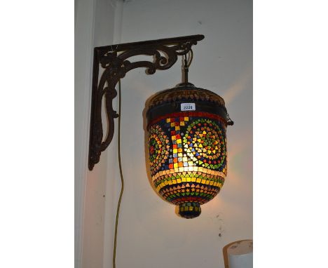 Coloured mosaic glass lantern on an iron wall bracket, 15ins high, 8.5ins diameter