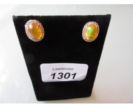 Pair of 18ct yellow gold fire opal and round brilliant cut diamond cluster stud earrings