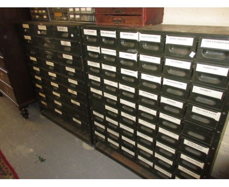 Two large green enamel banks of drawers containing a wide variety of miscellaneous parts and tools