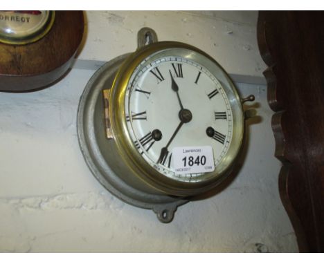 Small silvered metal cased ship's bulk head clock with brass bezel, the painted dial with Roman numerals and two train moveme