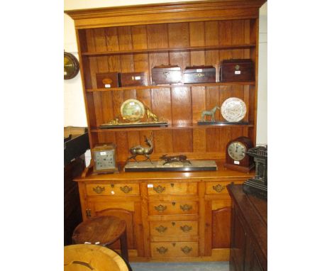 Reproduction oak dresser with a boarded shelf back above six small drawers and two arched panel doors