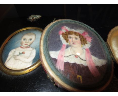 19th Century oval head and shoulder portrait miniature of a lady with lace bonnet, in folding red Morocco leather case and an