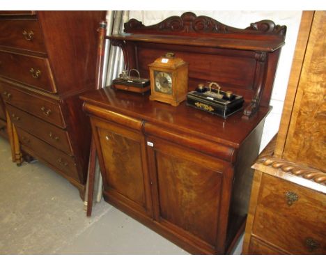 William IV mahogany chiffonier, the carved shelf back above an ogee frieze drawer and a pair of rectangular figured panelled 