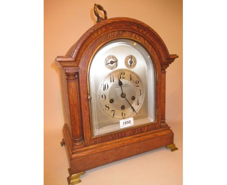 Early 20th Century oak bracket clock, the broken arch case with flanking pilasters, the silvered dial with Arabic numerals, c