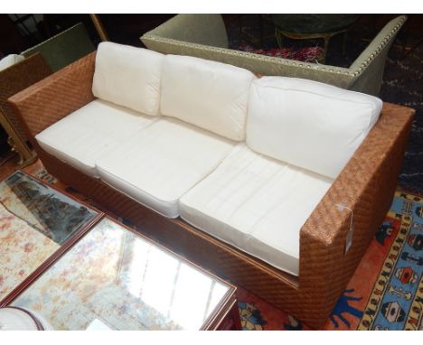 A 20th century three seat rattan sofa, upholstered with white loose cushions, W. 200cm.