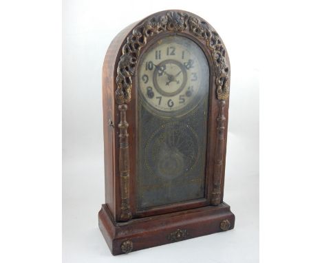 An early 20th century mantel clock, the arched case with gilt decorated glazed door and white dial set out in Arabic numerals