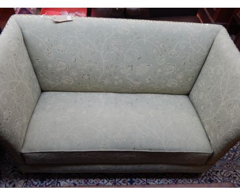 A mid 20th century upholstered two seat sofa, covered in an eau de nil floral fabric with brass stud, W. 141cm