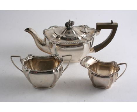 AN EDWARDIAN SMALL THREE PIECE TEA SET with flat bases & borders of gadrooning & foliate shells, by W. Atkin, Birmingham 1905