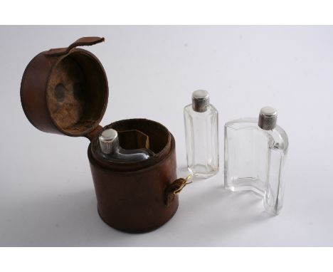 BY ASPREY & CO.LTD: A leather travelling case fitted with three mounted clear glass sectional bottles (neatly fitting into th
