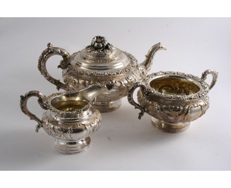 A WILLIAM IV ORNATE THREE-PIECE TEA SET with embossed squat circular bodies & circular bases, the tea pot with a large flower