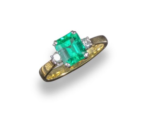 An emerald and diamond three-stone ring, the emerald-cut emerald weighs approximately 1.70cts, with a round brilliant-cut sho