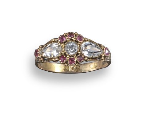 An early 19th century ruby and white stone ring, set within scrolling gold shoulders in 18ct gold, Birmingham hallmarks for 1