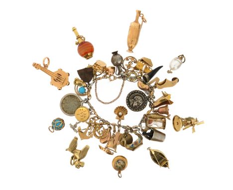 A gold charm bracelet with assorted charms, including a 9ct gold horseshoe, a 9ct gold scallop shell set with a seed pearl, a