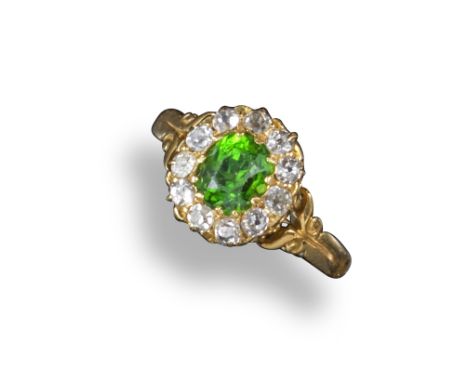 A Victorian demantoid garnet and diamond cluster ring, the oval-shaped garnet is set within a surround of old circular-cut di