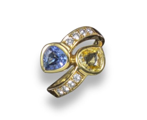 A sapphire and diamond crossover ring, the pear-shaped yellow and blue sapphires are rubover-set in yellow gold, with four ro