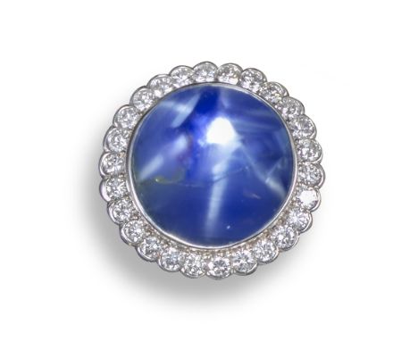 A star sapphire and diamond cluster ring, the circular blue cabochon sapphire weighs approximately 29.00cts, set within a sur