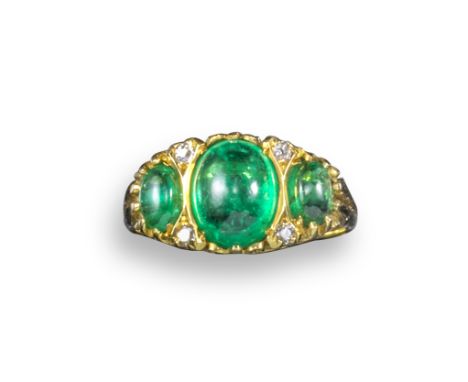 An emerald half-hoop ring, set with three graduated oval emerald cabochons in pierced and carved scroll mount with old circul