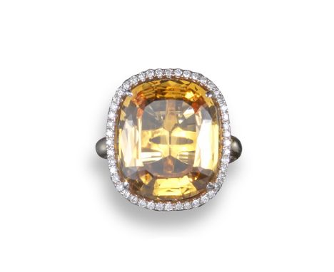 A Topaz and diamond cluster ring, the cushion-shaped orange topaz weighs approximately 13.00cts and is set within a surround 