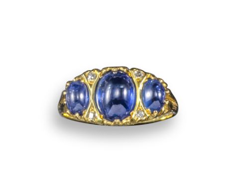 A sapphire half-hoop ring, set with three graduated oval sapphire cabochons with diamond pointers in a yellow gold pierced an