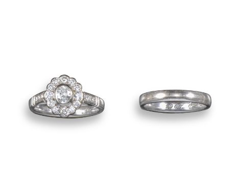 A diamond cluster ring, set with an oval-shaped diamond within a surround of circular-cut diamonds, with further circular-cut