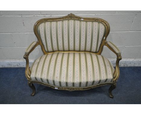 A 19TH CENTURY GILTWOOD SOFA, of small proportions, with a foliate crest, striped and floral upholstery, raised on front cabr