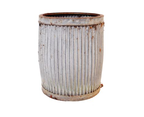 A vintage corrugated galvanised steel planter. Circular form, with ribbed sides. 44cm tall.