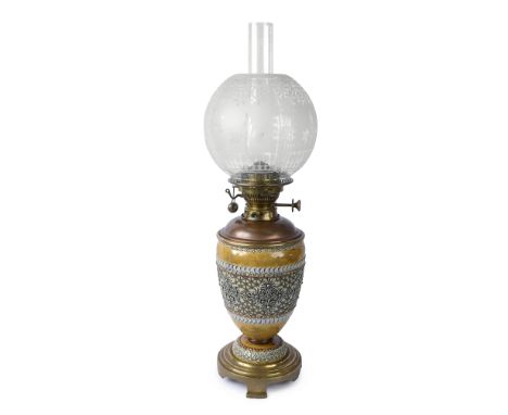 A late 19th century Doulton Lambeth brass mounted stoneware oil lampdecorated in relief with a band of floral decoration, fit
