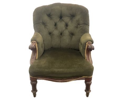 An early Victorian mahogany button back upholstered armchair shaped back, upholstered in green fabric, scroll arms and lappet