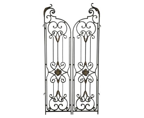 A pair of wrought iron garden gates, black painted, of scrollwork design with gilt acanthus leaf and quatreform flower head a