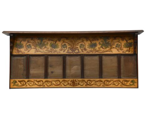 An Arts and Crafts walnut and polychrome decorated fruitwood wall hanging photograph framewith seven glazed apertures surmoun