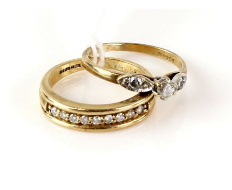 Two diamond rings, one vintage set with three round brilliant cut diamonds, and another set with a row of nine round brillian
