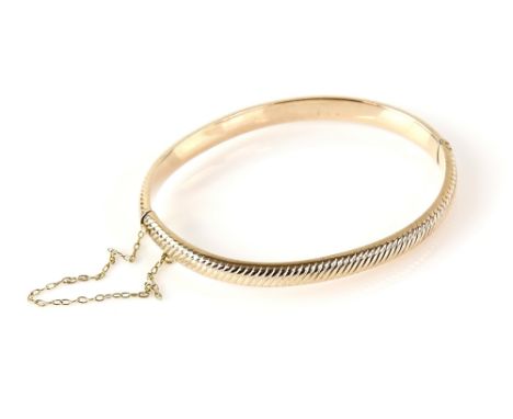 Vintage textured oval bangle, with concealed clasp and safety chain, testing as 9 ct.    CONDITION9 ct gross weight 8 grams
