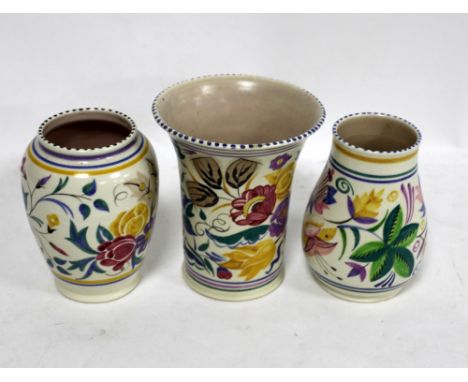 Three Poole pottery vases with floral decoration .    