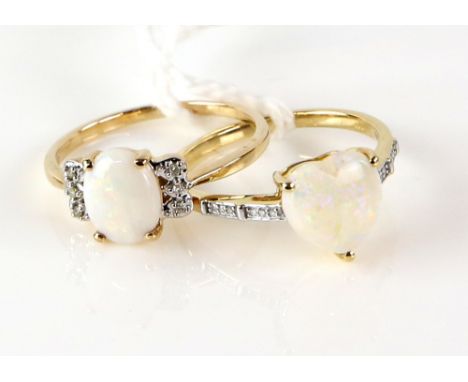 Two opal rings, one set with oval cabochon cut opal and diamond set shoulders, the other set with heart shaped opal, both rin